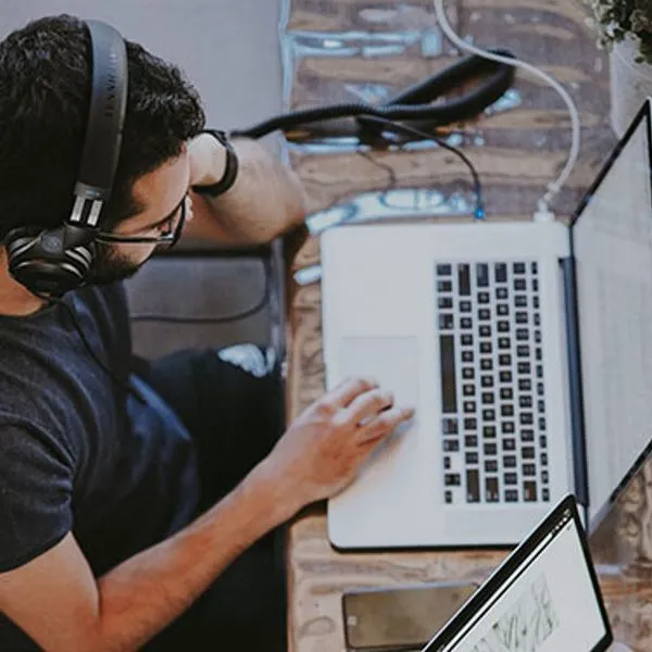 Person mit Headset im Gespräch an einem Laptop
